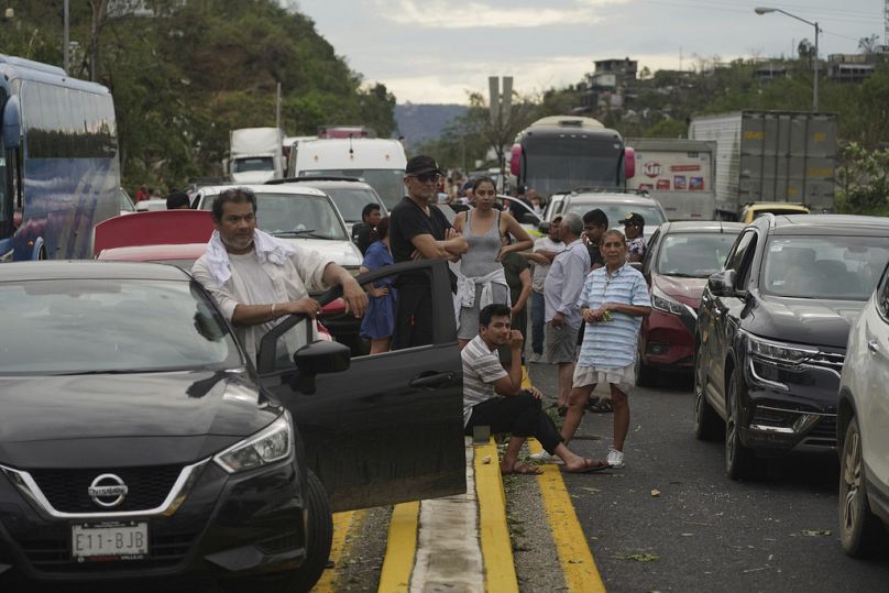 Les gens attendent que les équipes de réparation débouchent les routes après que l'ouragan Otis a dévasté Acapulco, au Mexique, le mercredi 25 octobre 2023.