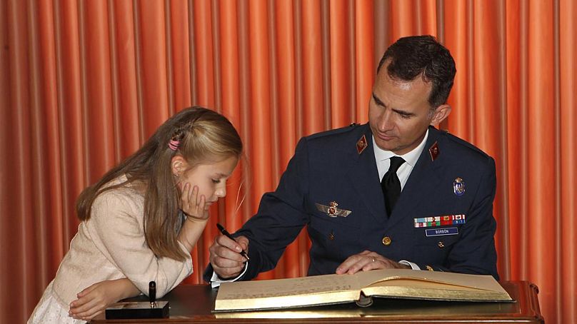 Leonor de Borbón regarde son père, le roi Felipe, signer un livre