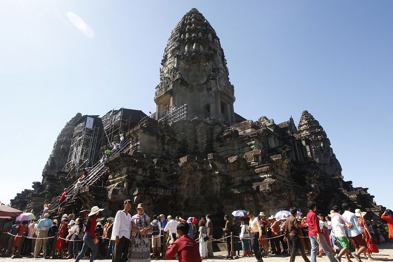 Les touristes font la queue pour intensifier le temple d'Angkor Wat à l'extérieur de Siem Reap, au Cambodge.