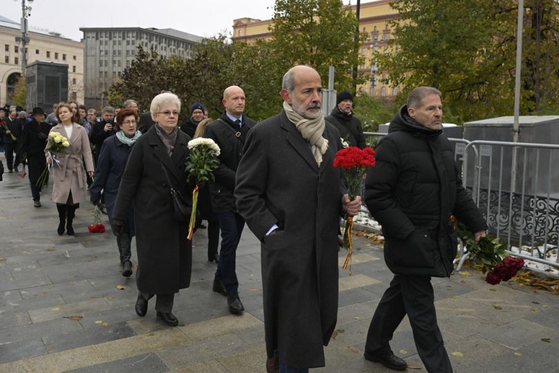 Des employés des missions diplomatiques marchent pour déposer des fleurs devant le monument où fut établi le premier camp du système carcéral politique du Goulag, à Loubianska.