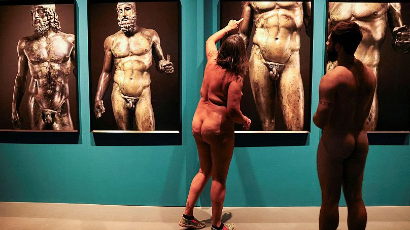 Le guide Edgard Mestre s'entretient avec Marta, 59 ans, alors qu'elles participent à une visite nudiste au Musée archéologique de Catalogne, Barcelone, Espagne.