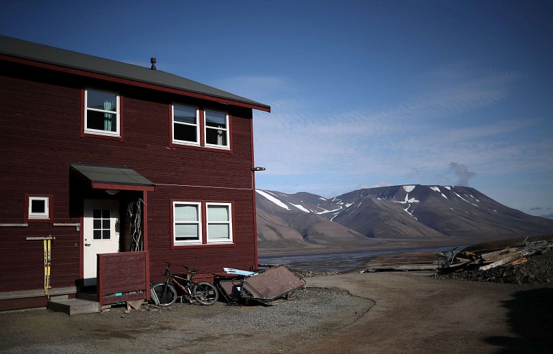 Une maison d'habitation est vue devant les montagnes enneigées de la ville de Longyearbyen à Svalbard, en Norvège.