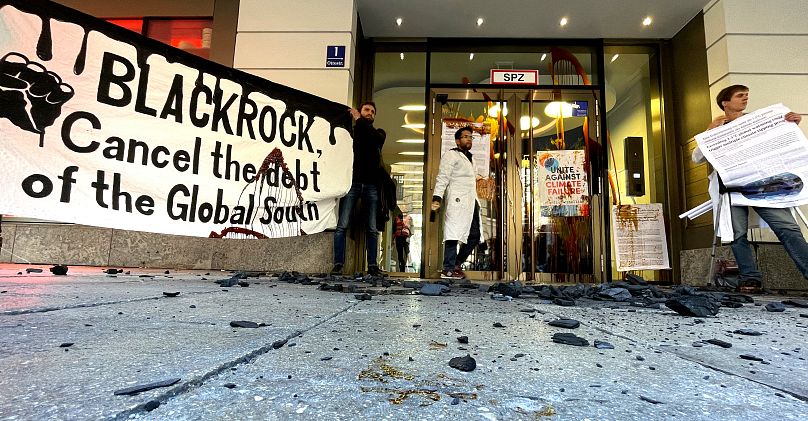 Des militants du groupe de lutte contre le changement climatique Scientist Rebellion manifestent devant le bâtiment Blackrock à Munich, en Allemagne, le 25 octobre 2022.