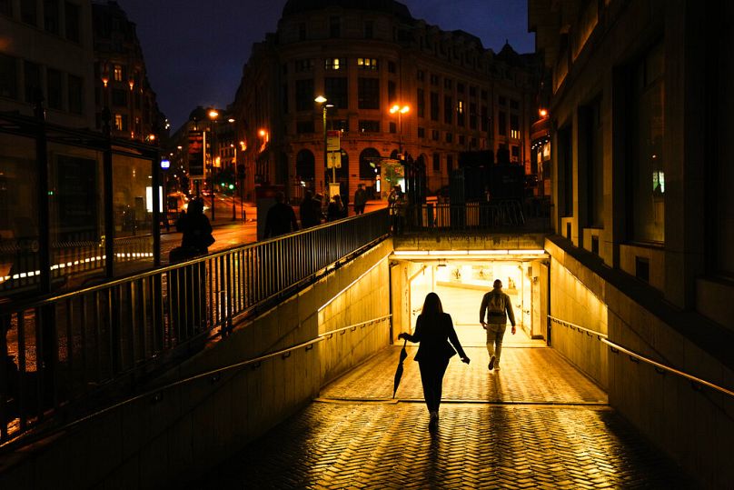 Des gens entrent dans la station de métro Central lors d'une journée d'été pluvieuse dans le centre-ville de Bruxelles, en juin 2021