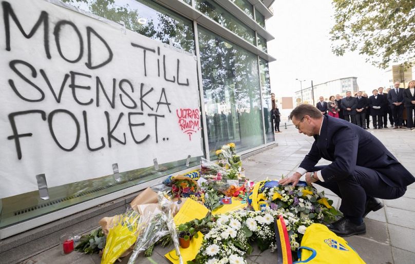 Le Premier ministre suédois Ulf Kristersson dépose des fleurs lors d'une commémoration en mémoire des victimes de l'attentat terroriste.