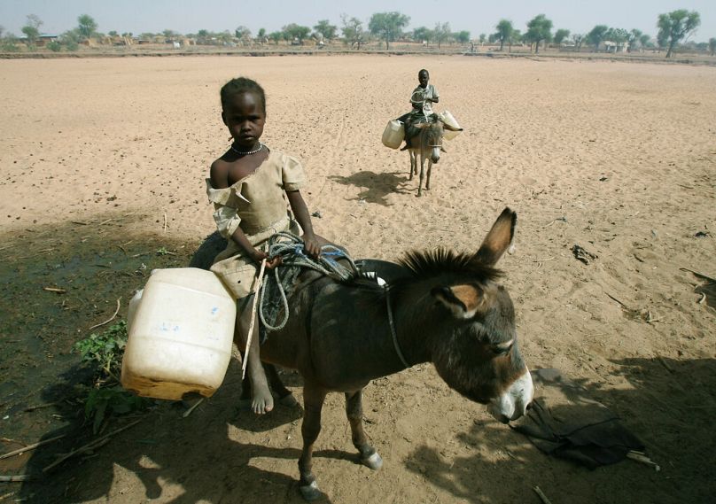Une jeune Soudanaise monte un âne pour aller chercher de l'eau dans la ville de Mukjar, dans l'ouest du Darfour, en avril 2007.