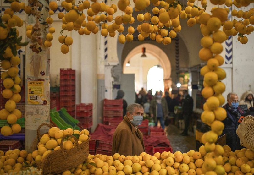 Un homme passe devant un étal de citrons sur le marché central, à Tunis, janvier 2021