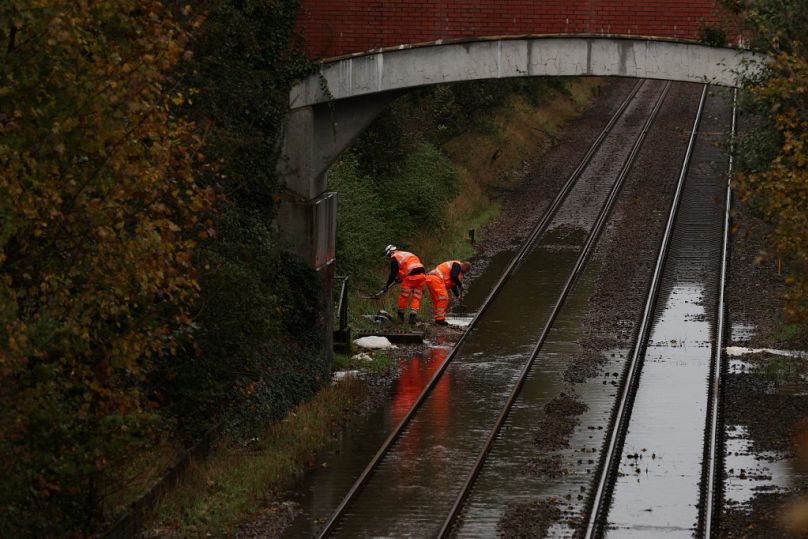 Des ouvriers tentent de nettoyer l'eau d'une voie ferrée inondée à Romsey, dans le sud de l'Angleterre, le 2 novembre 2023.