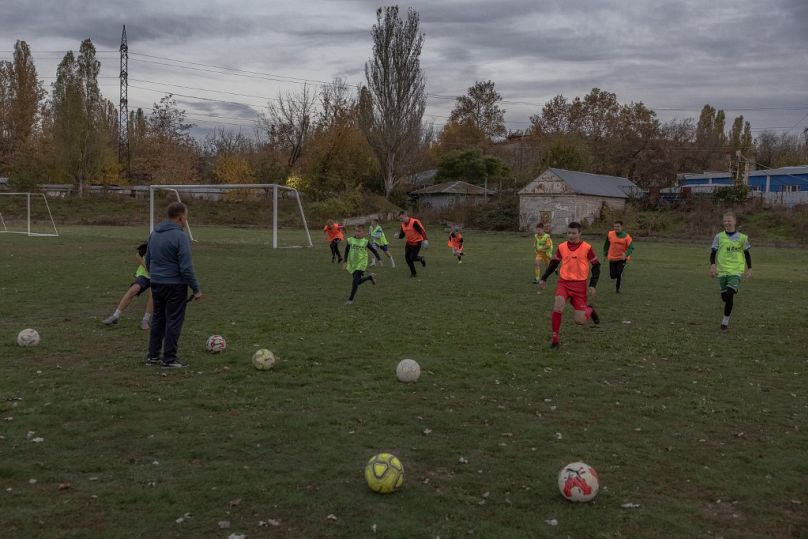 De jeunes garçons participent à un entraînement de football sur un terrain, dans la ville méridionale de Kherson, le 2 novembre 2023