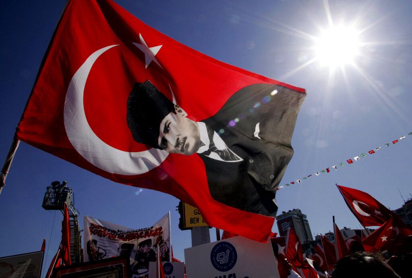 Des manifestants brandissent des drapeaux turcs et un drapeau avec la photo du fondateur de la Turquie moderne, Atatürk, lors d'un rassemblement pro-laïc à Izmir, en mai 2007.
