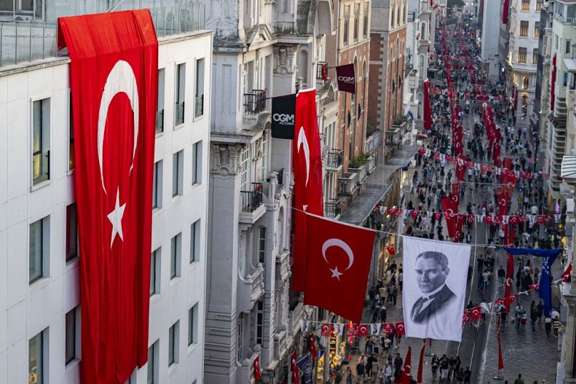 Des drapeaux nationaux turcs et une bannière représentant Mustafa Kemal Ataturk, le père fondateur de la République de Turquie, sont exposés sur l'avenue Istiklal à Istanbul, en octobre 2023.