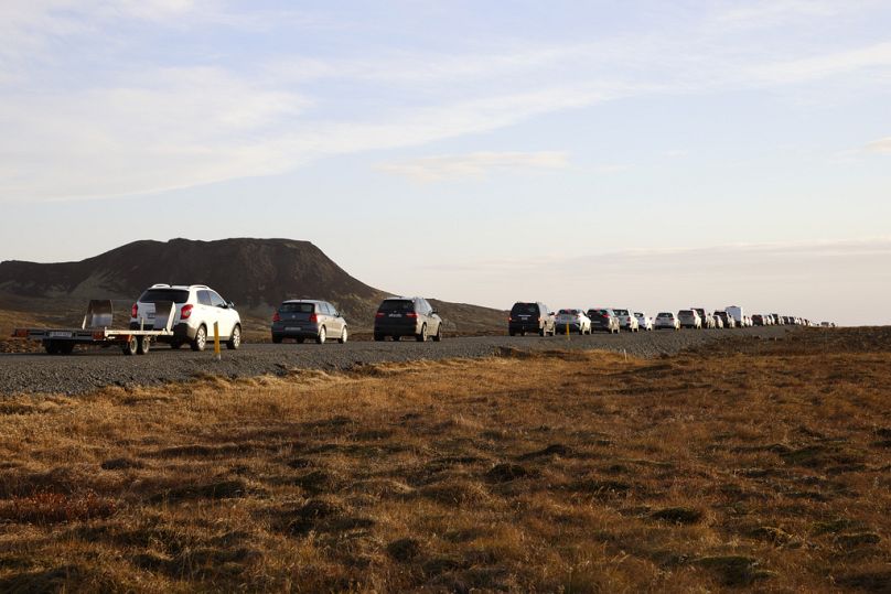 Une file de voitures en file d'attente sur une route en direction de la ville de Grindavik, en Islande, lundi 13 novembre.