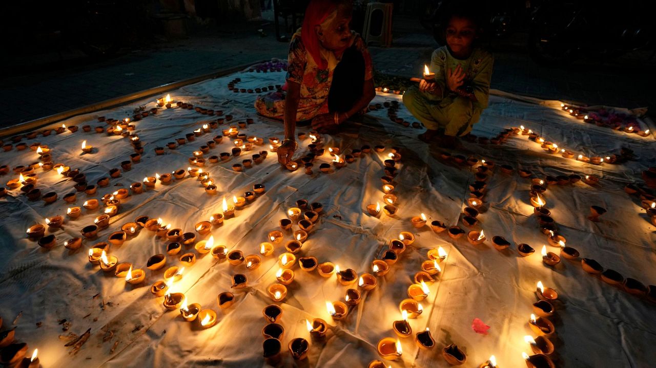 Une femme hindoue, à gauche, assiste à une cérémonie célébrant Diwali, la fête des lumières, au temple Somi Narin à Karachi, au Pakistan, le dimanche 12 novembre 2023.
