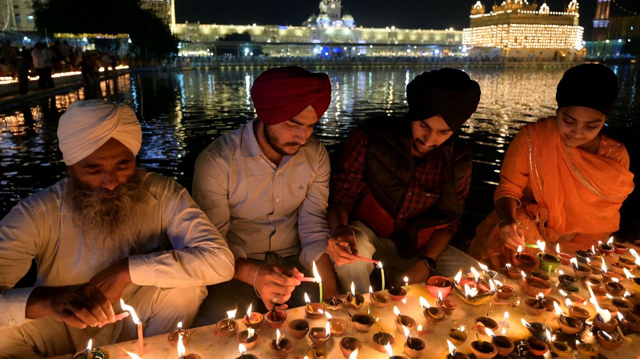 Des fidèles sikhs allument des lampes à huile à l'occasion du festival sikh Bandi Chhor Divas ou du festival Diwali au Temple d'Or illuminé d'Amritsar le 12 novembre 2023.