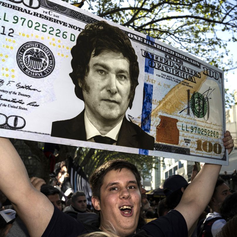 Agustin Salem tient un billet surdimensionné en dollars américains avec le visage du candidat à la présidence Javier Milei lors d'un rassemblement électoral à Buenos Aires, en Argentine, le lundi 25 septembre 2023.