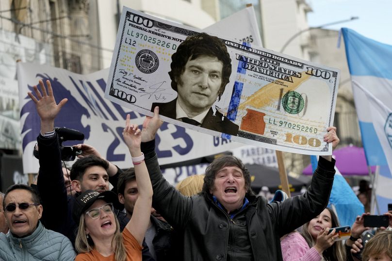 Javier Milei brandit un carton géant représentant un billet de 100 dollars américains arborant une image de son visage, lors d'un rassemblement à La Plata, en Argentine, le mardi 12 septembre 2023.