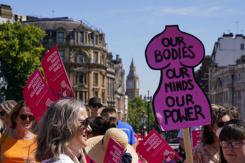 Des manifestants brandissent des pancartes alors qu’ils assistent à une marche en soutien au groupe Abortion Rights, à Londres, le samedi 9 juillet 2022.