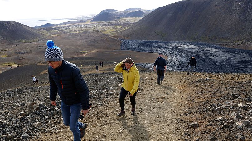 Des gens marchent pour observer les éruptions du volcan Fagradalsfjall en Islande, le 3 août 2022.