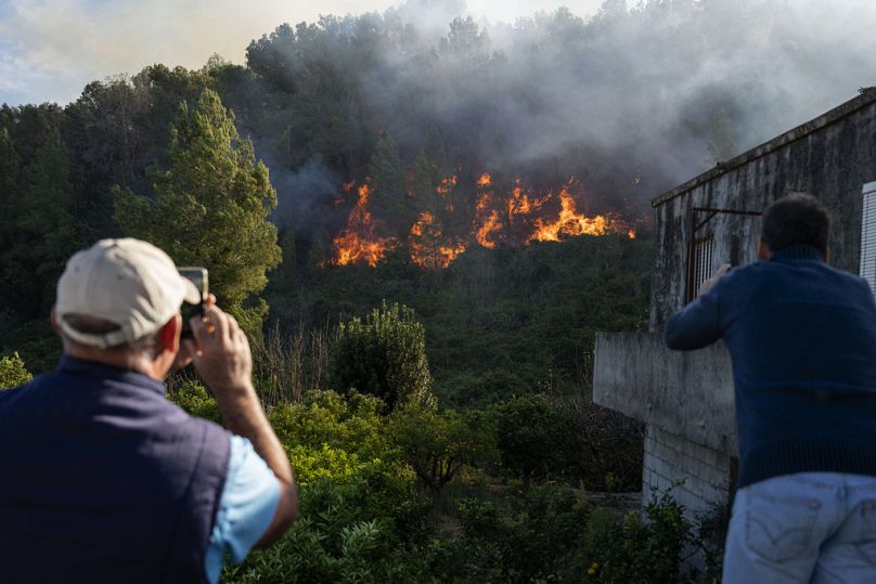 Les villageois prennent des photos alors qu'un incendie de forêt progresse près de la ville orientale de Palma de Gandia, à Valence.