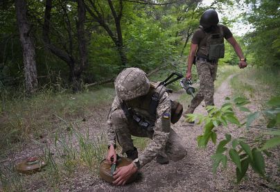 Des soldats ukrainiens posent des mines antichar sur une route forestière sur le chemin potentiel des troupes russes dans la région de Donetsk, en Ukraine, en juin 2022.