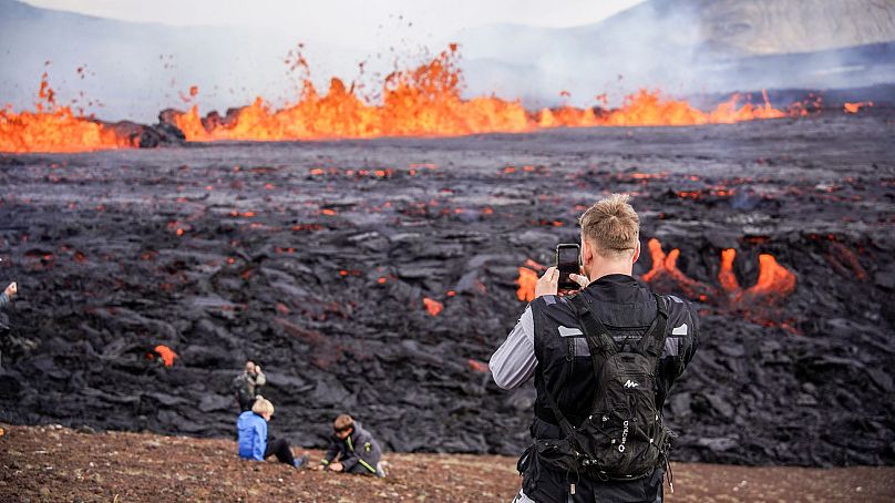 Des gens regardent la lave couler sur le volcan Fagradalsfjall en Islande le 3 août 2022.