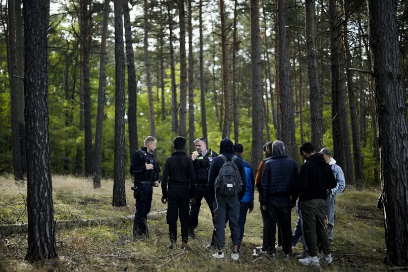 Un officier de la police fédérale parle dans sa radio tandis qu'avec un collègue, il traque un groupe de migrants qui ont franchi illégalement la frontière entre la Pologne et l'Allemagne.