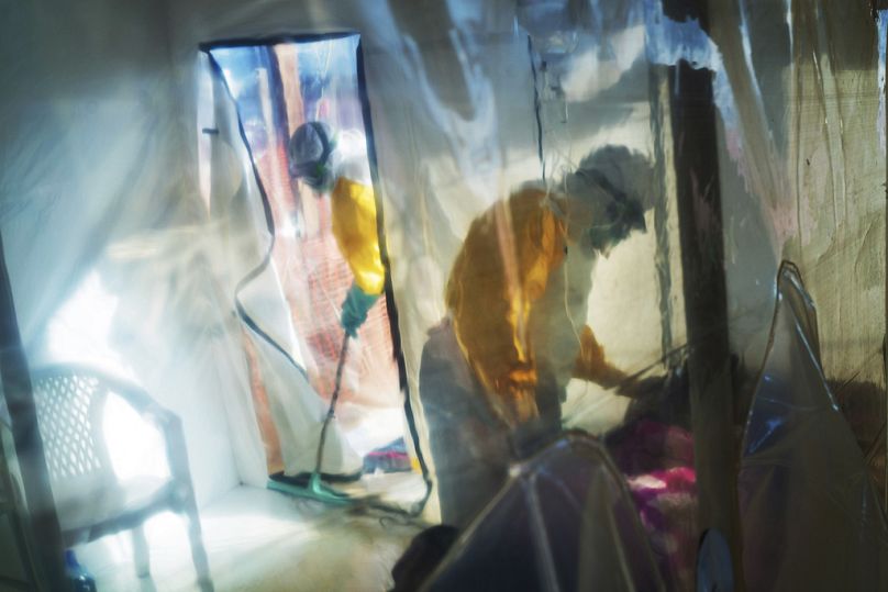 Des agents de santé portant des combinaisons de protection s'occupent d'une victime d'Ebola détenue dans une tente d'isolement à Beni, en République démocratique du Congo, le samedi 13 juillet 2019.