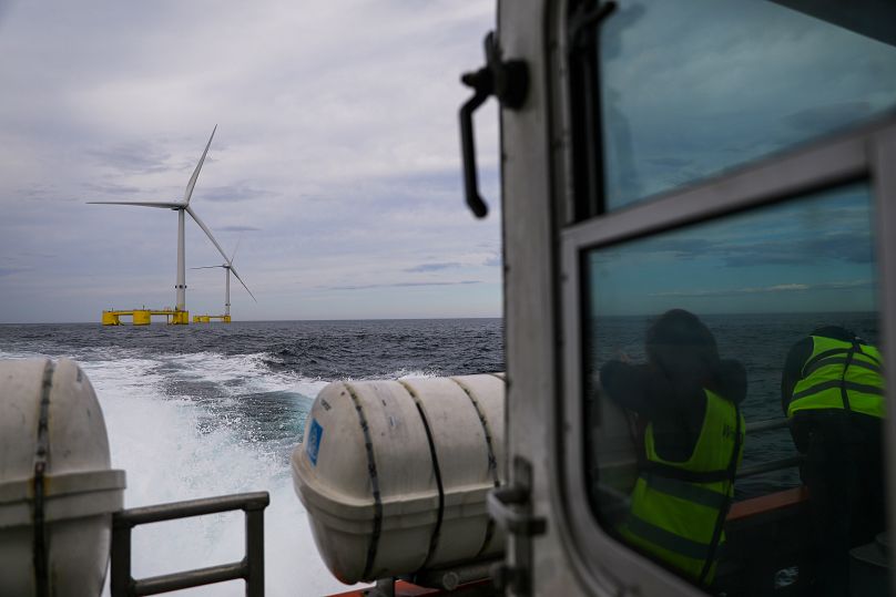 Des visiteurs en bateau observent les turbines du projet WindFloat Atlantic, une plateforme flottante de production d'énergie éolienne offshore, à 20 kilomètres au large de la côte de Viana do Castelo.