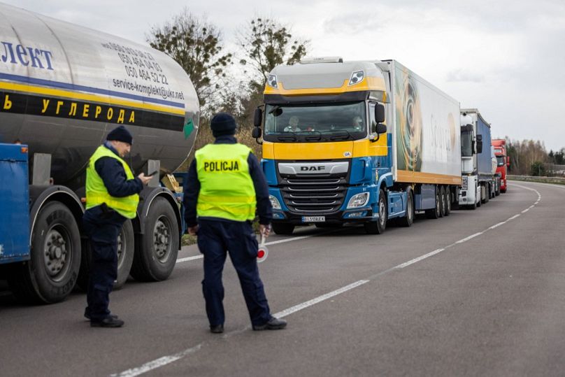 Des policiers polonais sont vus à côté d'une file de camions alors que les propriétaires d'entreprises de transport bloquent l'accès au poste frontière polono-ukrainien à Dorohusk, en Pologne, le 6 novembre.
