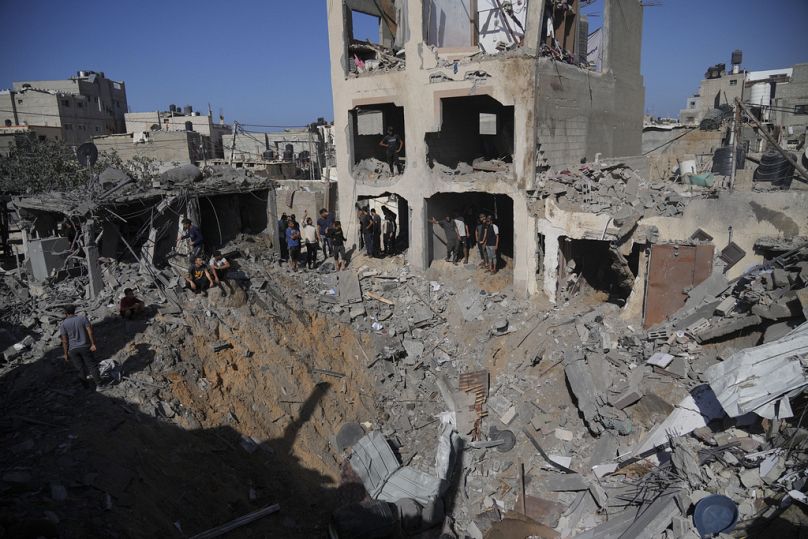Des Palestiniens regardent les bâtiments détruits lors des bombardements israéliens dans la morgue de Deir al Balah, dans la bande de Gaza, le mardi 7 novembre 2023.
