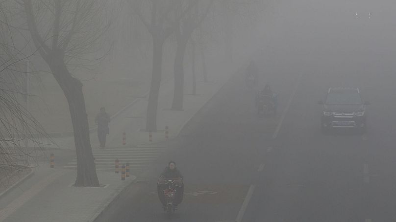Des gens conduisent et roulent au milieu du smog à Pékin, en Chine, le 14 février 2017.