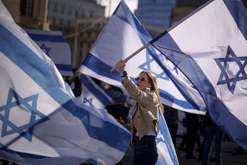 DOSSIER – Une femme tient un drapeau israélien lors d’un rassemblement de solidarité avec Israël et les otages du Hamas à Gaza à Bucarest, Roumanie, le 12 novembre 2023.