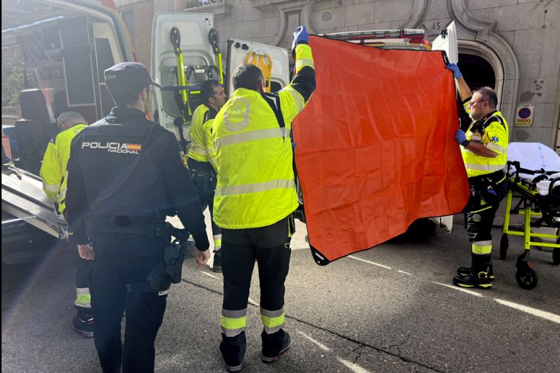 Les ambulanciers couvrent la vue d'une ambulance garée sur le lieu d'une fusillade à Madrid, le jeudi 9 novembre 2023.