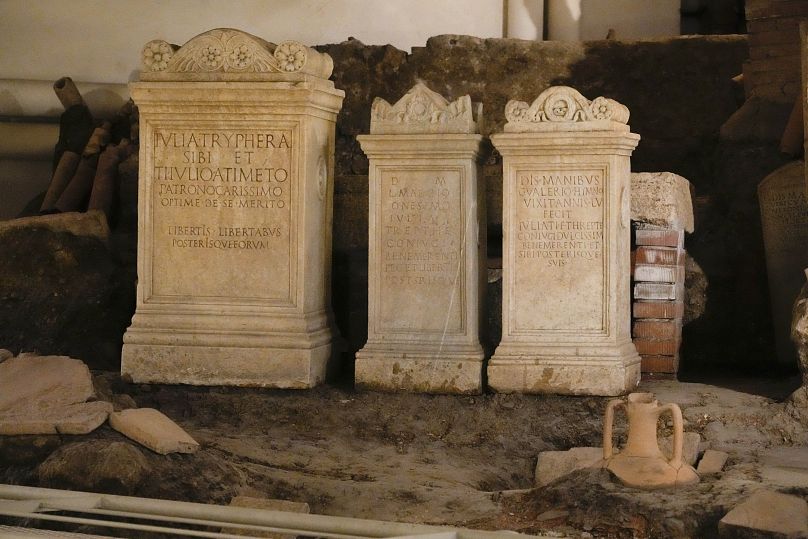 Des pierres tombales sont exposées à l'intérieur d'une ancienne nécropole le long de la via triomphalis, une zone archéologique contenant un cimetière romain.