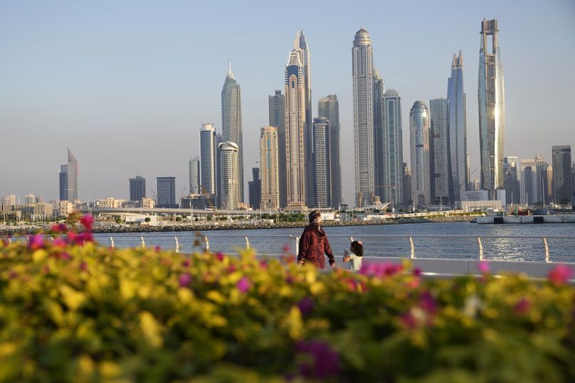 Les gens marchent avec l'horizon en arrière-plan alors que Dubaï, aux Émirats arabes unis, accueille le Sommet des Nations Unies sur le climat COP28, le mardi 5 décembre 2023.