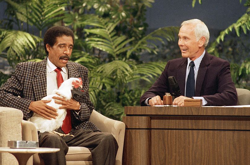 Richard Pryor tient un poulet tout en parlant avec Johnny Carson sur