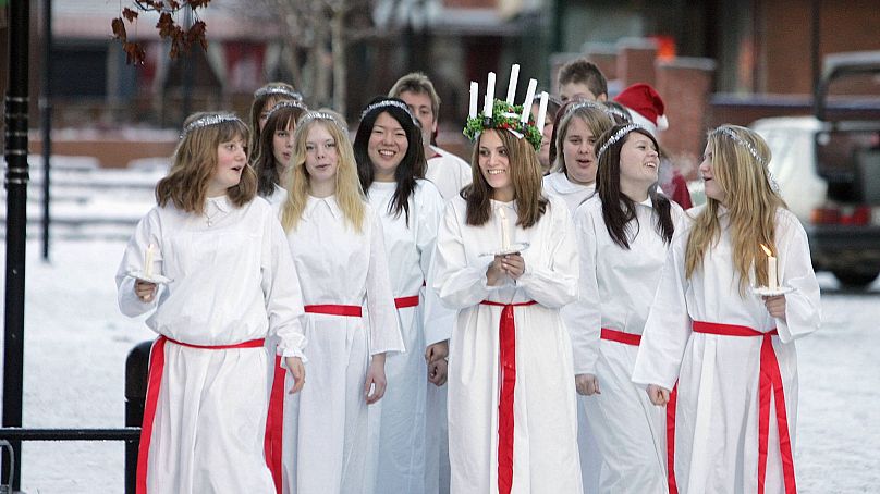 Une jeune fille habillée en Sainte-Lucie et ses servantes se promènent dans les rues de la petite ville d'Aange (Ånge), à ​​400 km au nord de Stockholm