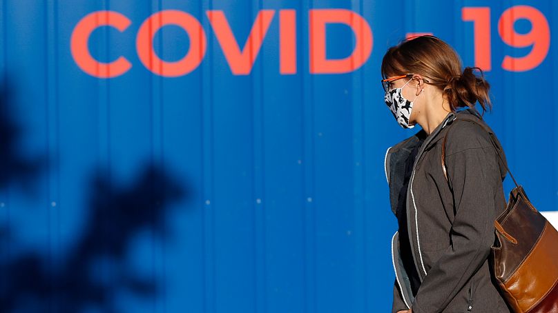 Une femme portant un masque marche pour se faire tester pour le COVID-19 à Prague, en République tchèque.