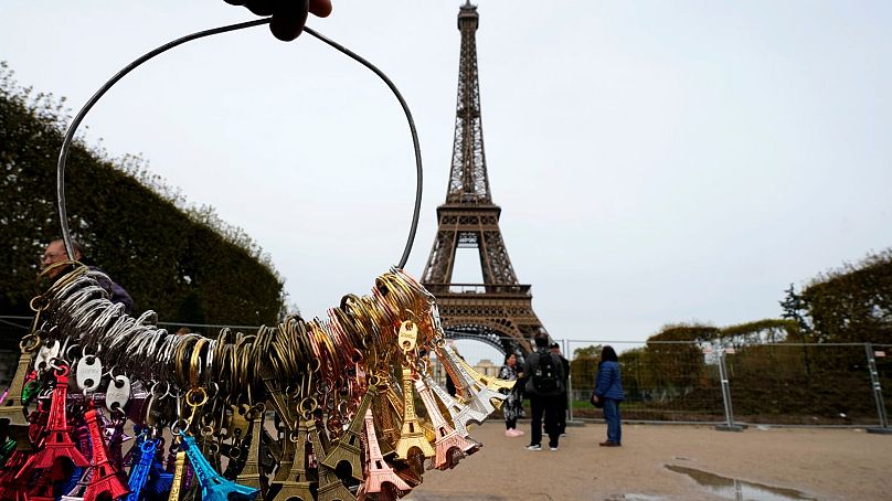 Un vendeur de souvenirs vend aux touristes devant la Tour Eiffel