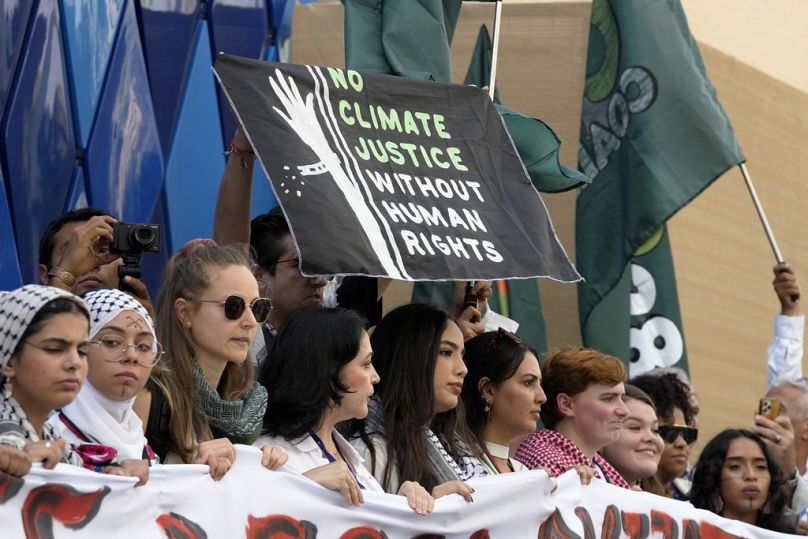 Des manifestants pro-palestiniens participant à une manifestation contre la guerre entre Israël et le Hamas tiennent une pancarte lors du Sommet sur le climat COP28 à Dubaï, aux Émirats arabes unis.