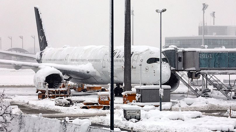 Un avion de Lufthansa est stationné à l'aéroport enneigé de Munich, en Allemagne, le 2 décembre 2023.