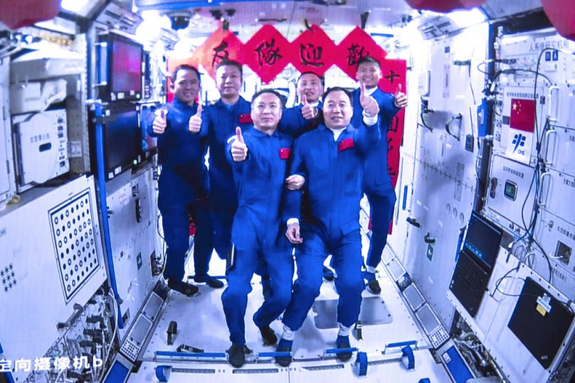Les équipages de Shenzhou-15 et Shenzhou-16 prennent des photos de groupe à l'intérieur du module central Tianhe de la station spatiale chinoise, mai 2023.
