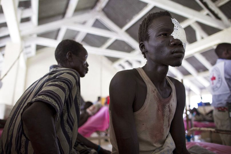 Un homme est assis sur un lit d'hôpital après avoir été soigné pour une blessure à l'œil à l'hôpital de Bor, État de Jonglei, Soudan du Sud, juillet 2013.