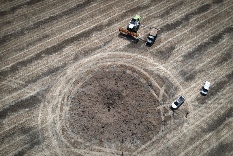 Un agriculteur récupère sa récolte dans un champ à dix kilomètres de la ligne de front dans la région de Dnipropetrovsk, juillet 2022