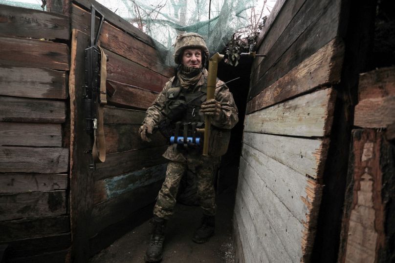 Un militaire ukrainien tient un périscope sur sa position sur la ligne de front avec les séparatistes soutenus par la Russie, près de la petite ville de Marinka, dans la région de Donetsk, le 20 avril 2021.