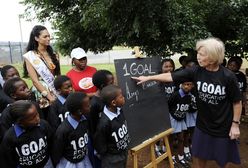 La baronne Glenys Kinnock (à droite) et Miss Afrique du Sud 2008 Tatum Keshwar (à gauche) posent avec les élèves d'une école de Soweto pour la campagne 1BUT en 2009.