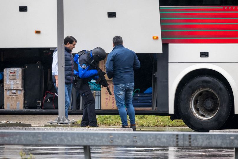 Des policiers contrôlent un bus près de Saint-Maurice alors qu'ils recherchent un homme armé qui a tué deux personnes et en a blessé une autre à Sion, dans le sud de la Suisse, le 11 décembre 2020.