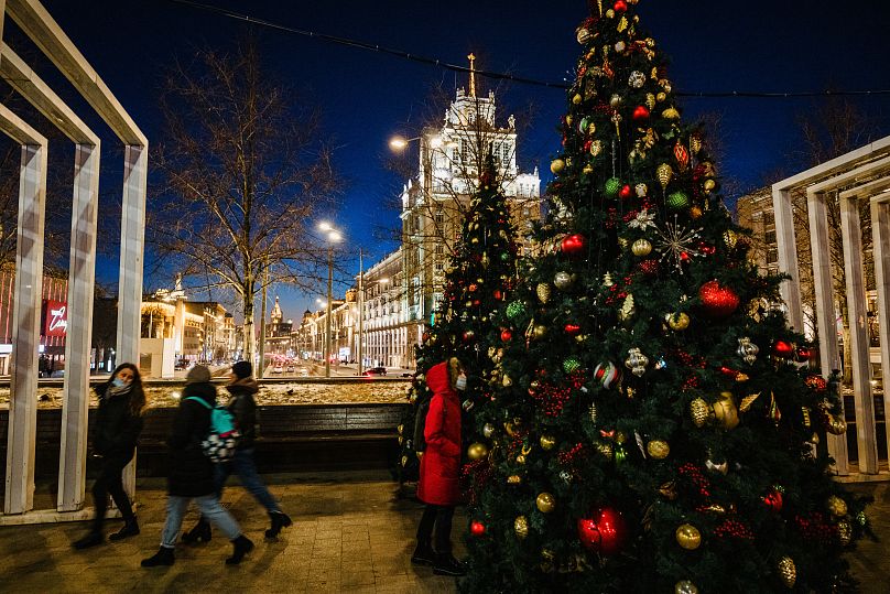 Des passants passent devant des arbres de Noël décorés à Moscou le 6 décembre 2020, en pleine crise liée à la pandémie de Covid-19 provoquée par le nouveau coronavirus.  La Russie confirme