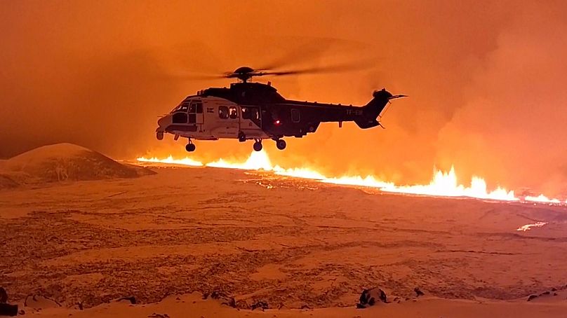Un hélicoptère de la Garde côtière islandaise vole près du magma sur une colline près de Grindavik, dans la péninsule islandaise de Reykjanes, les 18 et 19 décembre 2023.