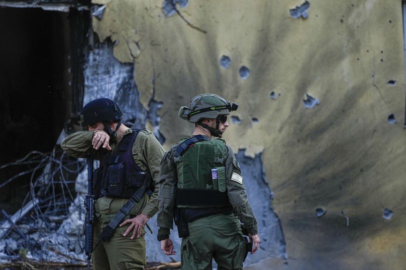 Des soldats israéliens passent devant des maisons détruites par des militants du Hamas au kibboutz Beeri, en Israël, en octobre.